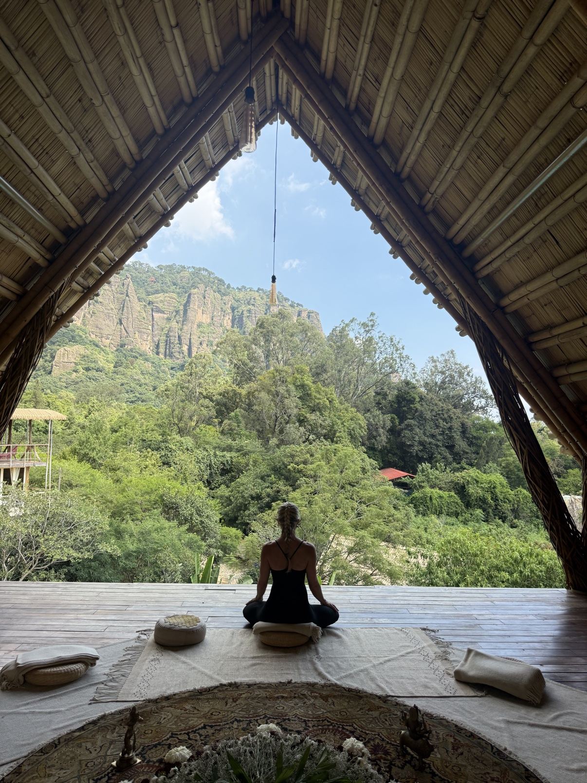 Sally meditating in an open-air shala overlooking the jungle