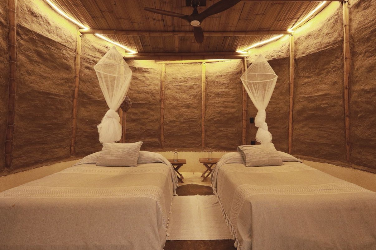 Inside the tipi, two beds with mosquito nets